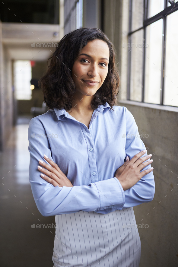 Young mixed race businesswoman standing with arms crossed - Stock Photo - Images