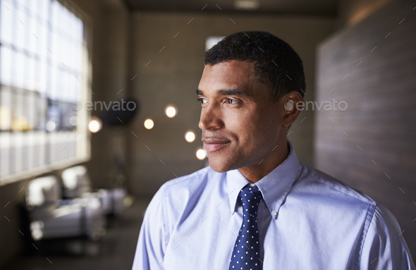 Mixed race businessman looking away smiling, close up - Stock Photo - Images