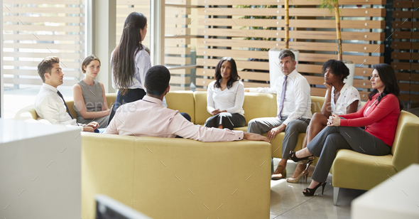 Businesswoman presenting at a team meeting in lounge area - Stock Photo - Images