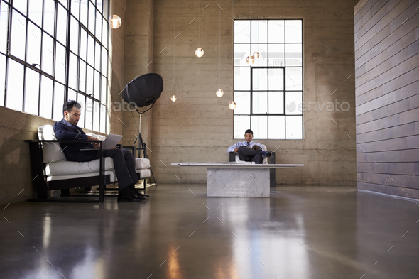 Two men sitting in the foyer of a business building - Stock Photo - Images
