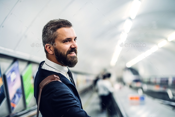 Hipster businessman using escalator in subway, travelling to work. - Stock Photo - Images