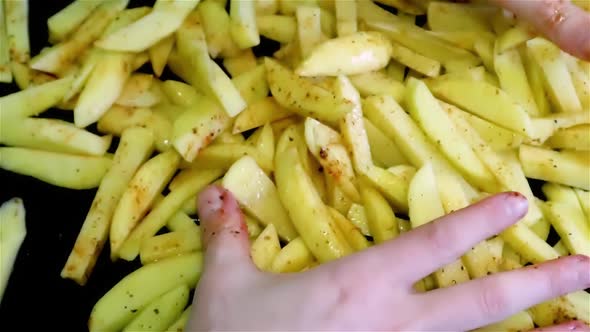 Mix spices with long raw fries potatoes by hands