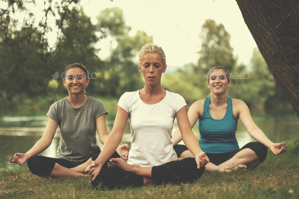 women meditating and doing yoga exercise - Stock Photo - Images