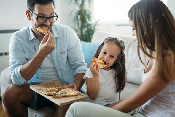 Portrait of happy family sharing pizza at home Stock Photo by nd3000