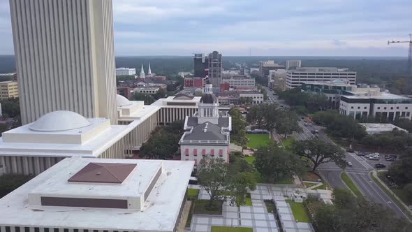 Flag waves atop Old Capitol building with New Capitol just behind in downtown Tallahassee, Florida. alt