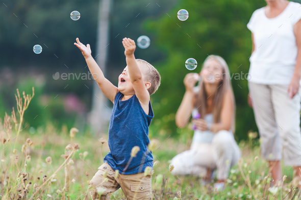 Happy Child With Family Having A Great Time Blowing Bubbles Stock