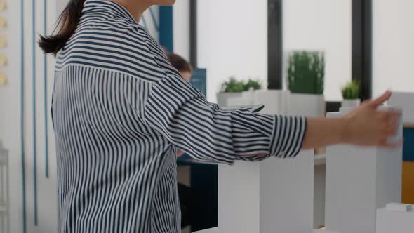 Close Up of Architect Holding Tablet and Analyzing Building Model to Plan Layout alt