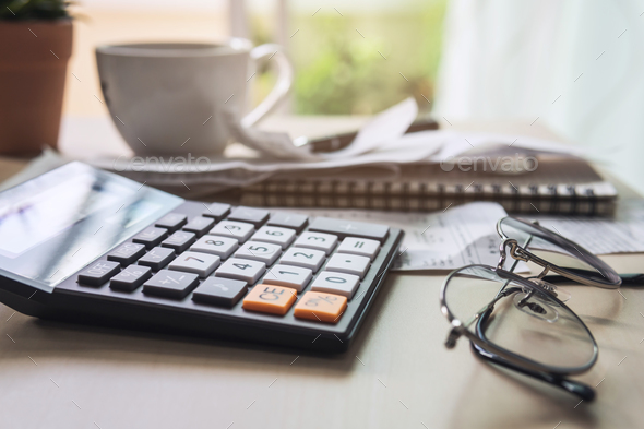 calculator with bills, taxes, bank account balance and calculating home expenses - Stock Photo - Images
