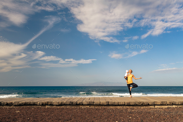Life balance. Yoga girl meditating and relaxing holding baby tod - Stock Photo - Images