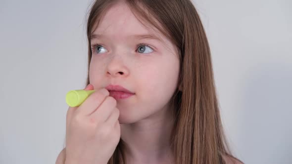 Little Girl Paints Lips with Hygienic Lipstick