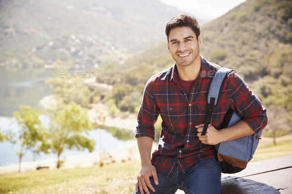 Young Hispanic man smiling during mountain hike, portrait - Stock Photo - Images