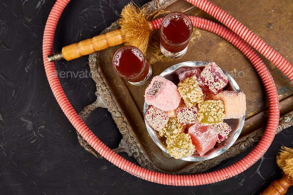 Set of various Turkish delight in bowl on metal tray near hookah tube - Stock Photo - Images