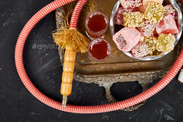 Set of various Turkish delight in bowl on metal tray near hookah tube - Stock Photo - Images