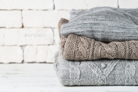 Stack of cozy woolen clothes on white Stock Photo by Nadianb