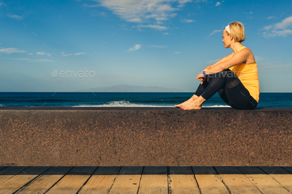 Yoga girl meditating and relaxing in yoga pose, ocean view - Stock Photo - Images