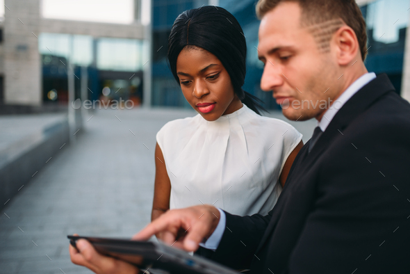 Business woman and businessman looks on laptop - Stock Photo - Images