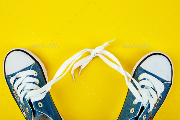 Blue female or male sneakers on yellow paper background - Stock Photo - Images