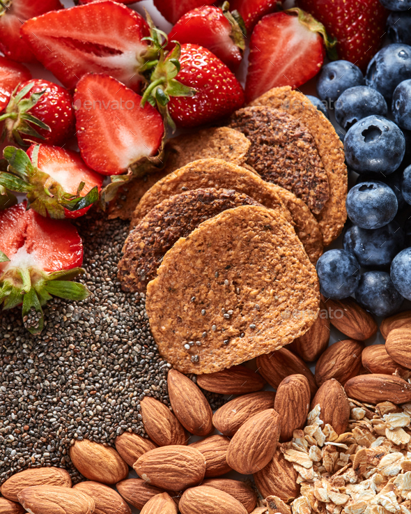 Fresh organic ingredients for dietary homemade natural breakfast - berries, granola, nuts, chia - Stock Photo - Images