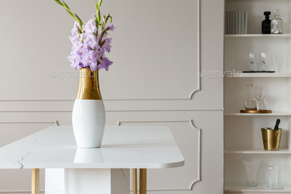 Lavender purple flowers in a golden vase on a white marble table - Stock Photo - Images
