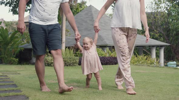 Parents Lifting Child up by Hands alt