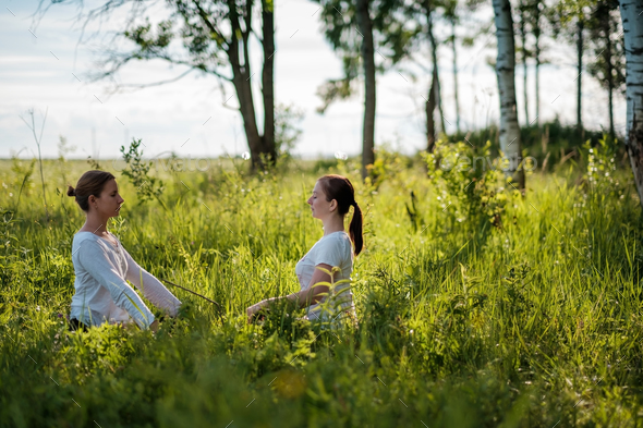 Portrait of two young woman enjoying pranayama - Stock Photo - Images