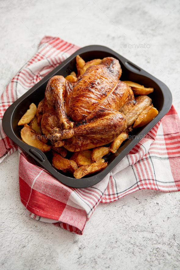 Roasted chicken or turkey with potatoes in black steel mold - Stock Photo - Images