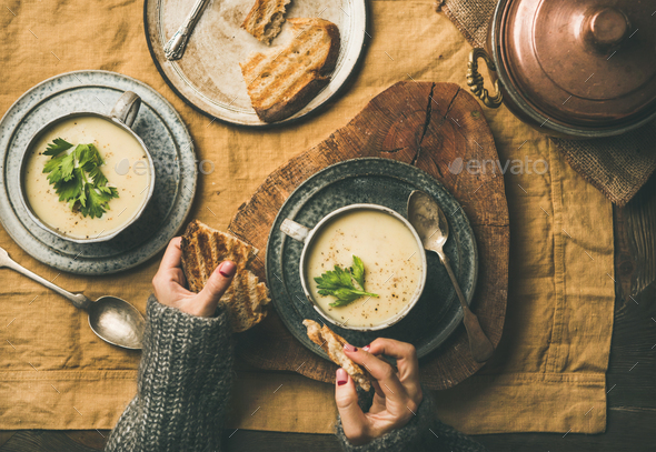Celery cream soup and female hands with grilled bread - Stock Photo - Images