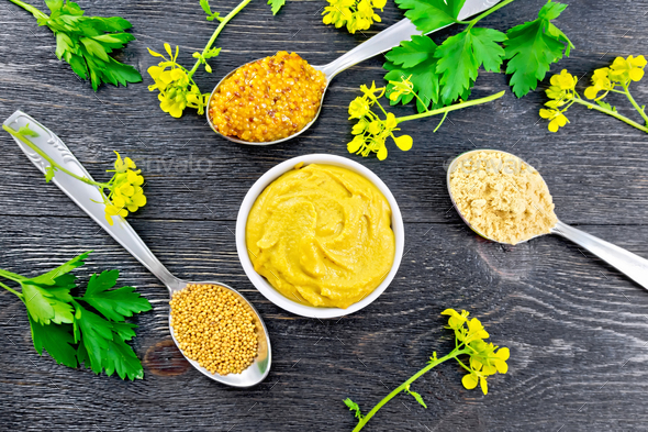 Mustard different in bowl and spoons on black board top - Stock Photo - Images