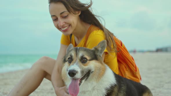 Attractive Young Woman Smiling and Spending Time Together with Her Pet Cute Corgi Dog Outdoors at alt