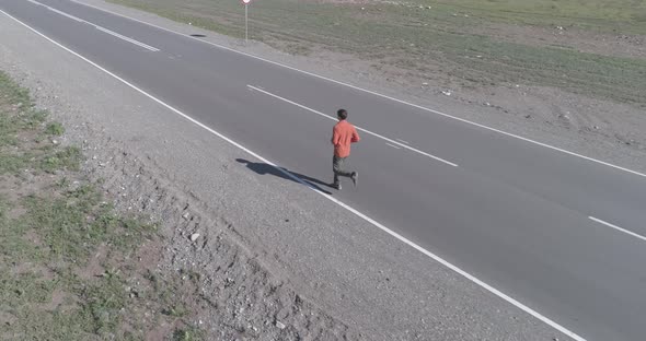 Low Altitude Flight in Front of Sporty Man at Perfect Asphalt Road alt