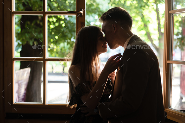 Young couple in love standing by the window