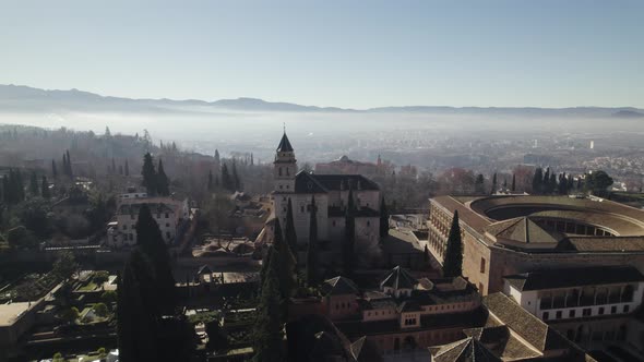 Flyover the famous Alhambra Islamic architectonic palace and fortress, on mystic morning fog horizon