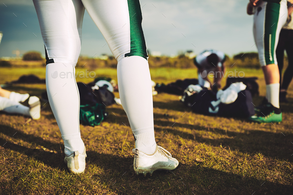 Closeup of football players on a field with their equipment - Stock Photo - Images