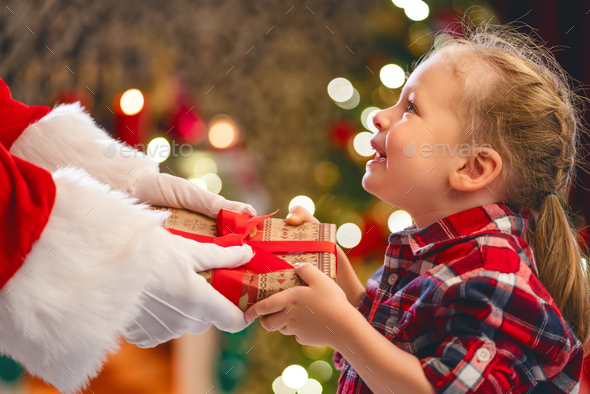 Santa Claus giving gift to child - Stock Photo - Images