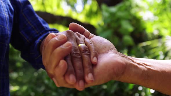 Senior couple holding hands alt