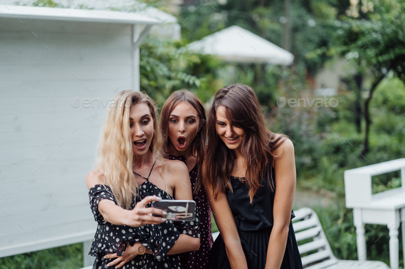 Three girls discuss photo - Stock Photo - Images