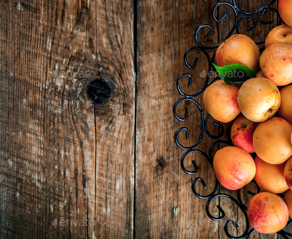 Bowl of harvested apricots.  Fresh apricots on wooden backgroun - Stock Photo - Images