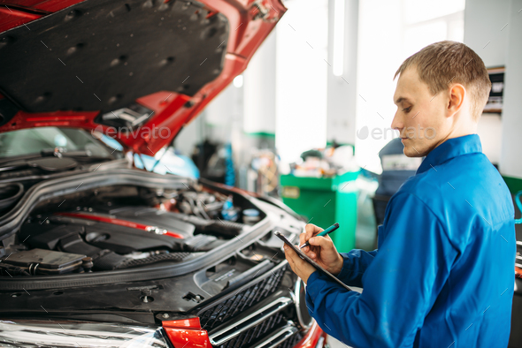 Technician fills check list, car with opened hood - Stock Photo - Images