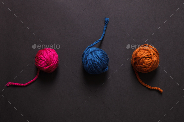 Colorful yarn clews on black background - Stock Photo - Images