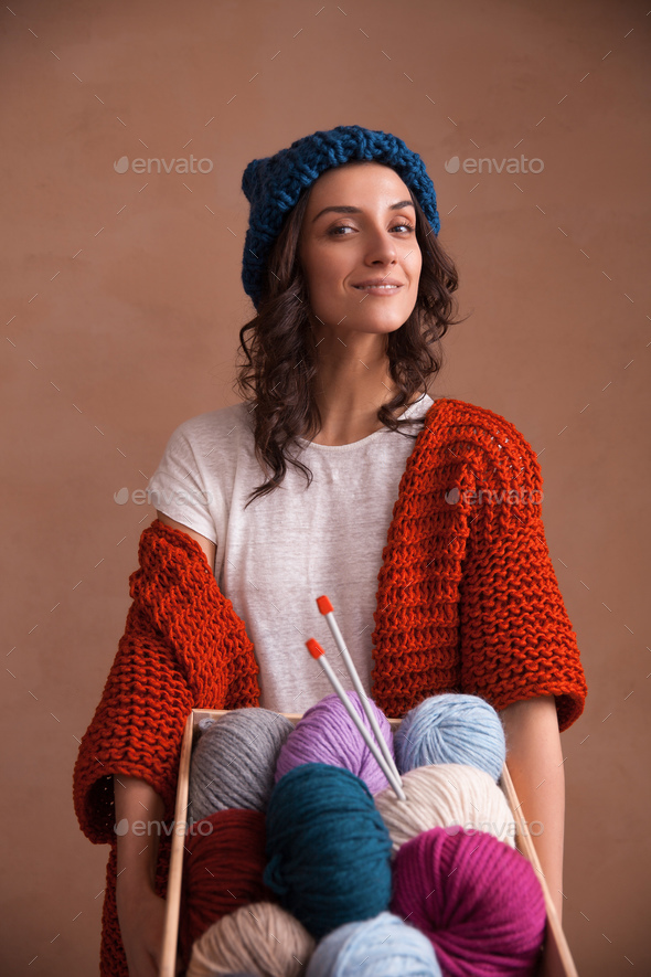 Woman holding the box witn yarn clews and knitting needles - Stock Photo - Images