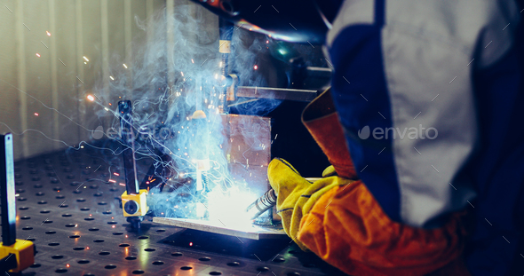 man welds at the factory working in metal industry - Stock Photo - Images