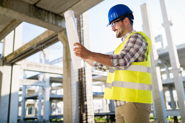 Portrait of male site contractor engineer with hard hat holding blue print paper - Stock Photo - Images
