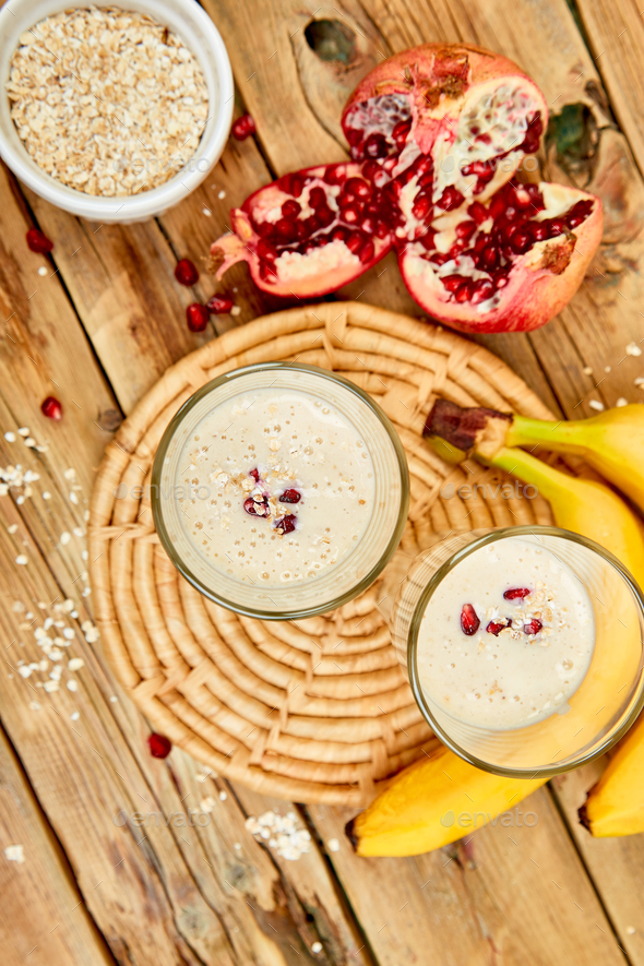 Smoothie with oat or oatmeal, banana and pomegranate on wooden rustic background - Stock Photo - Images