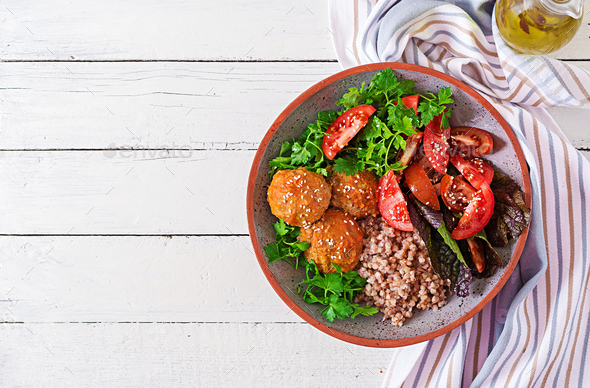 Meatballs, salad of tomatoes and buckwheat porridge on white wooden table. - Stock Photo - Images