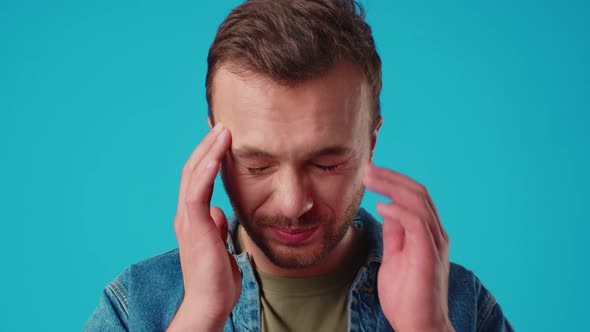 Young Handsome Man Standing Over Isolated Blue Background Suffering From Headache