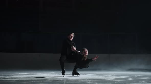 Slow Motion Young Couple of Artistic Figure Skaters is Performing a Pair Skating Choreography on Ice alt