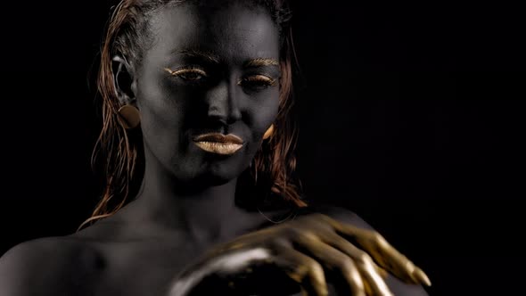 Art Portrait of a Young Female Model with Black Skin Golden Lips Hands Eyes alt