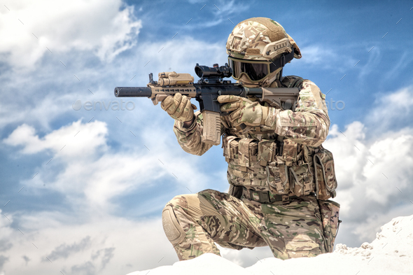 Airsoft game participant aiming with rifle replica - Stock Photo - Images