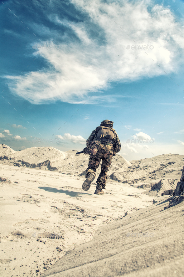 Man in military uniform playing airsoft in sands - Stock Photo - Images