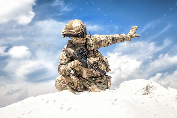 Equipped airsoft player showing halt hand signal - Stock Photo - Images